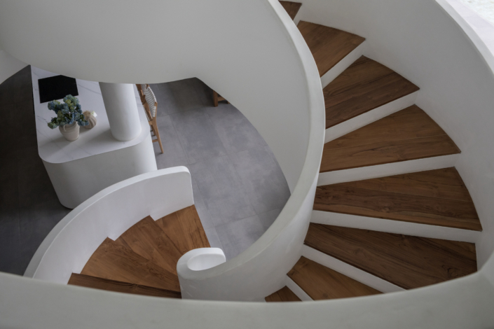 Curved wooden staircase with modern white walls at Jipsi Villas Canggu Bali