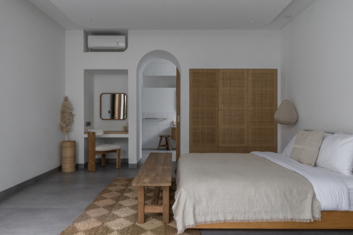 Spacious bedroom with minimalist design and wooden furniture at Jipsi Villas Canggu Bali
