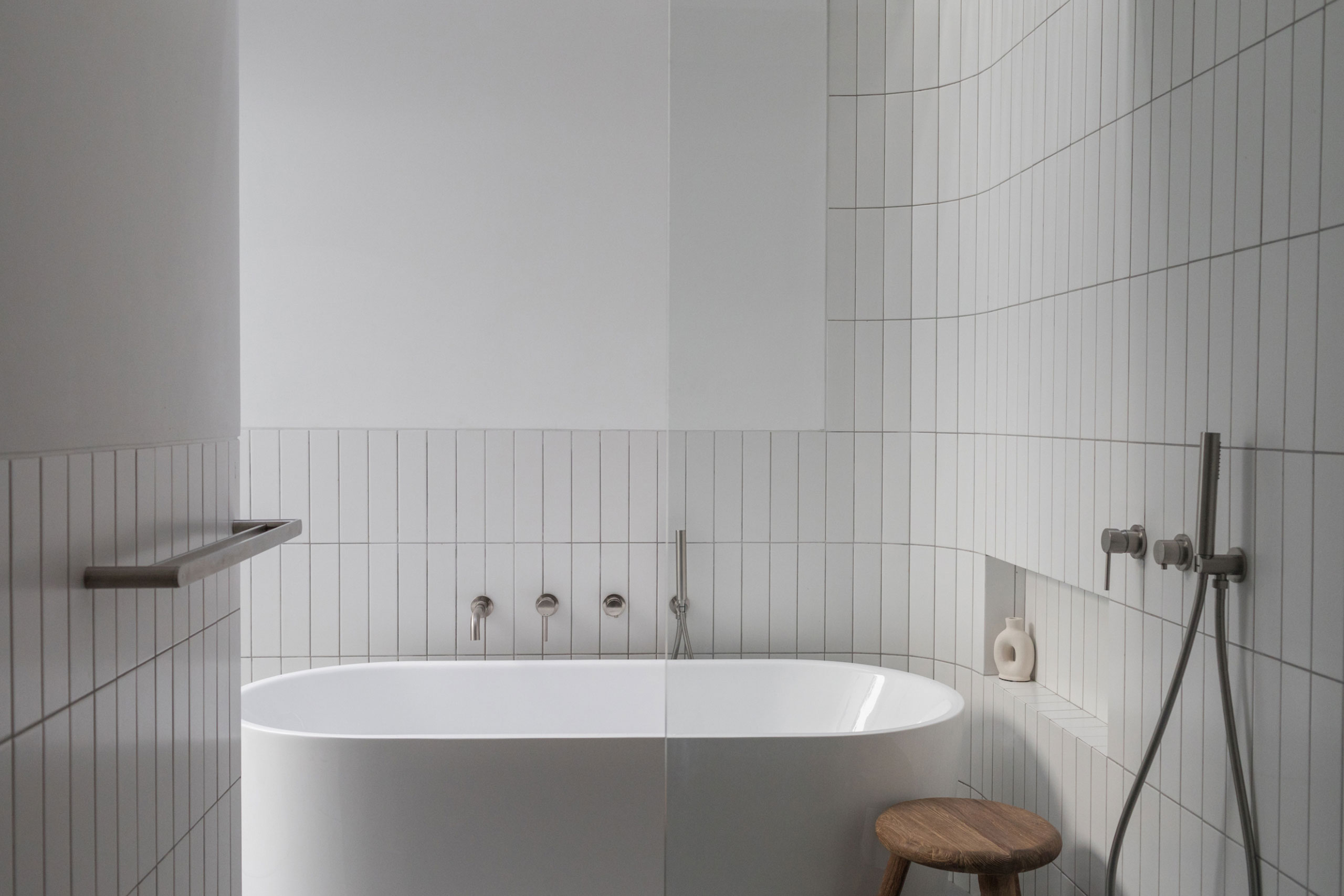 Minimalist bathroom with white bathtub and modern fixtures at Jipsi Villas Bali.