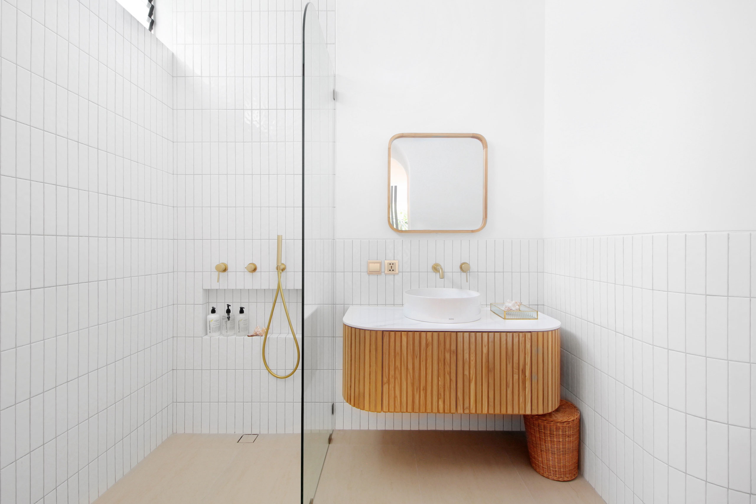 Modern minimalist bathroom with wooden vanity and gold fixtures at Jipsi Villas Bali