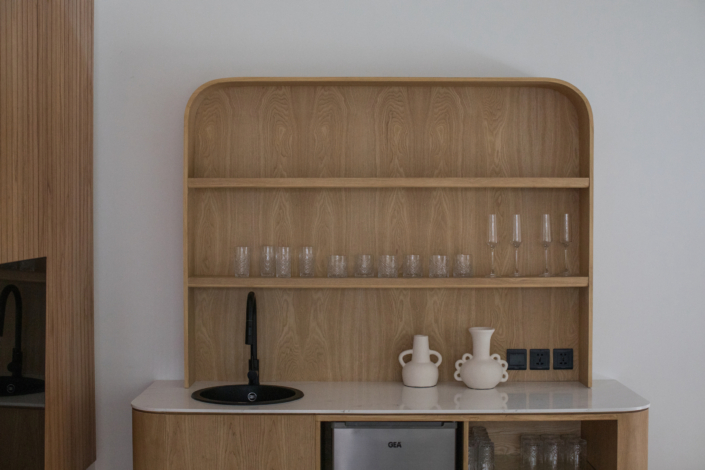 Wooden minibar cabinet with black sink and glassware at Jipsi Villas Canggu Bali