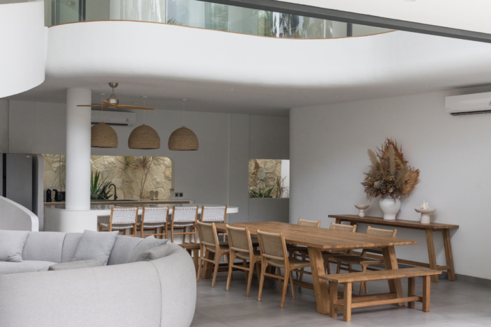 Spacious dining area and modern kitchen with natural wood furniture at Jipsi Villas Canggu Bali