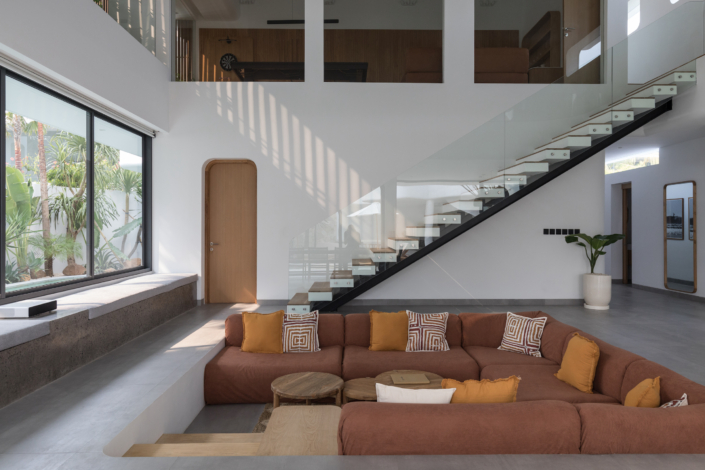 Modern sunken living room with glass staircase at Jipsi Villas Bali