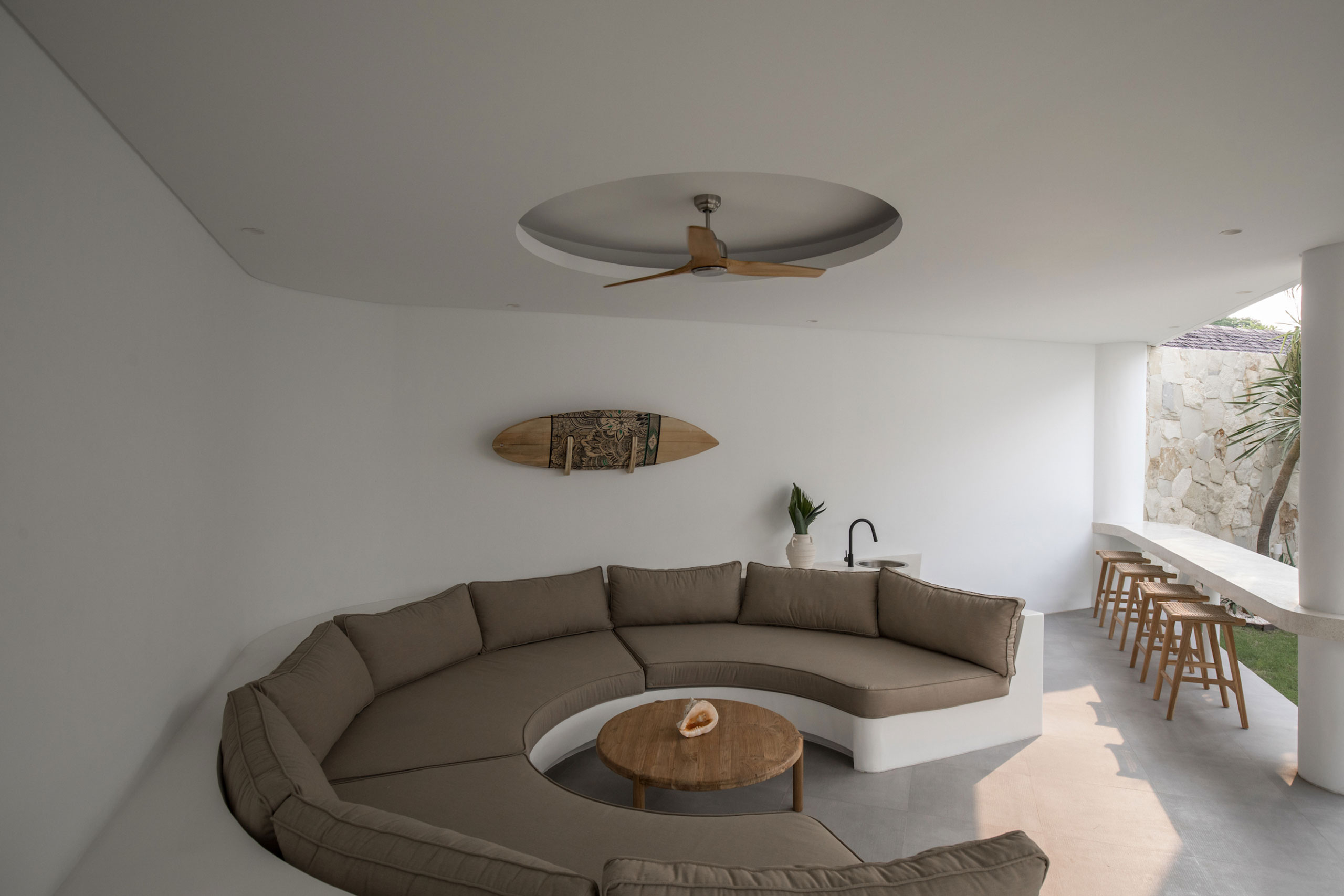 Modern open living area with circular sofa and bar counter at Jipsi Villas Bali.