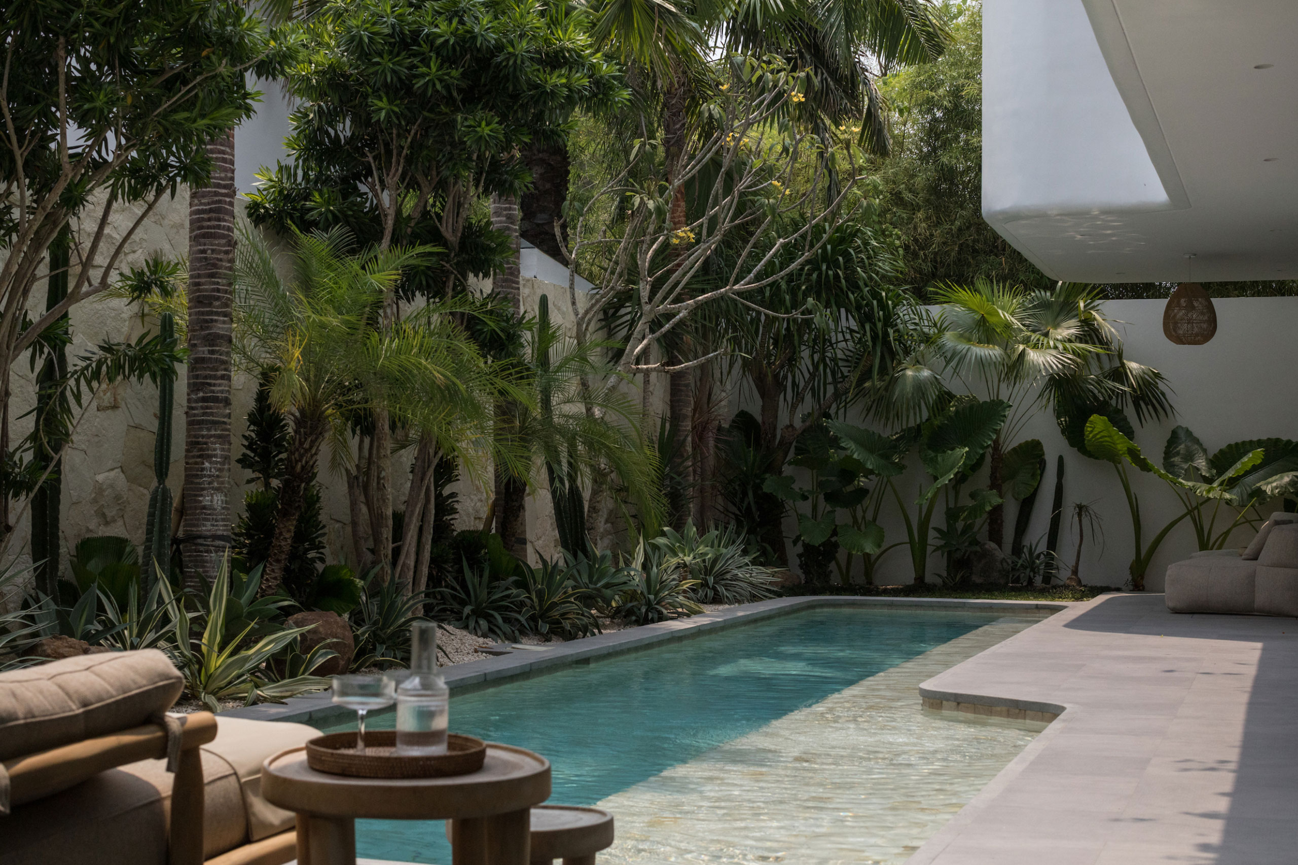Luxury private pool surrounded by tropical plants and modern minimalist architecture at Jipsi Villas Bali