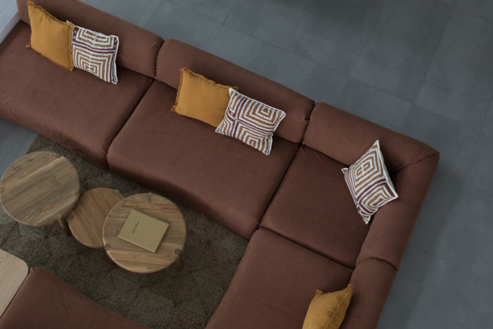 Brown sectional sofa with yellow cushions and wooden coffee tables at Jipsi Villas Canggu Bali