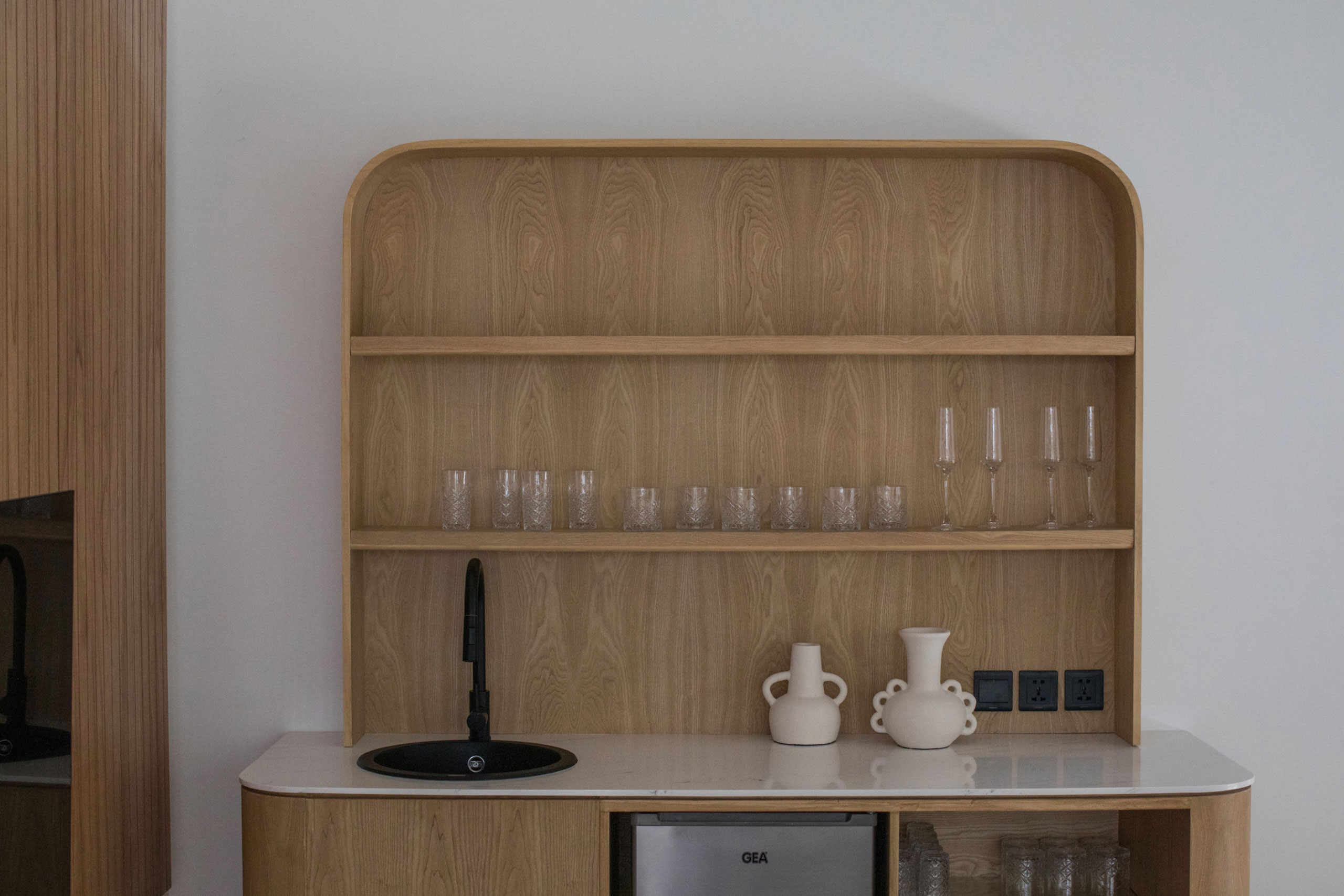 Stylish wooden mini bar with sink and glassware at Jipsi Villas Bali